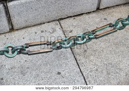 Chain Links On The Background Of The Sidewalk.