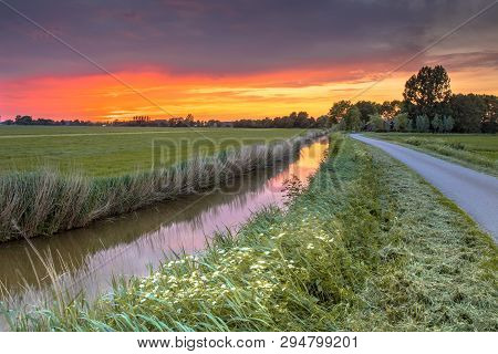Landscape Scene Over River And Road At Sunset In Flat Agricultural Area In Groningen Province The Ne