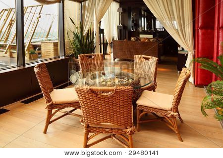 Güzel hasır sandalye ve masa boş şık restoranda