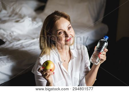 Beautiful, Healthy Woman Openning Bottel Of Mineral Fresh Drinking Water In The Morning At Home.