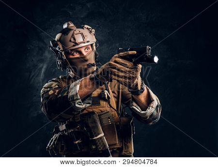 Elite Unit, Special Forces Soldier In Camouflage Uniform Holding A Gun With A Flashlight And Laims A