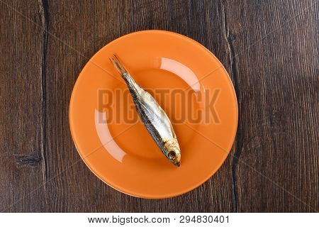 Cold Smoked Baltic Herring On An Orange Plate Over A Wooden Background. Smoked Baltic Herring Smoked
