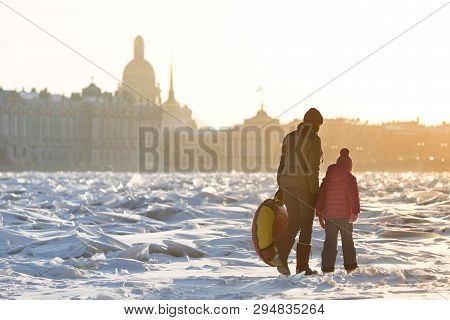 Mom And Child In Bright Clothes Walking On The Ice Of Frozen Neva In Sunny Winter Day, Hermitage On 
