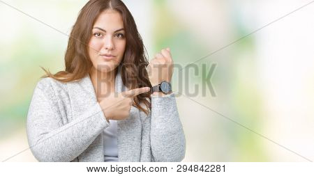 Beautiful plus size young woman wearing winter jacket over isolated background In hurry pointing to watch time, impatience, upset and angry for deadline delay