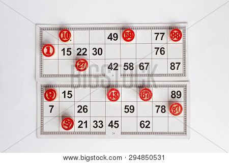 Bingo Or Lotto Game. Wooden Kegs Of Lotto On Cards. Cards And Chips For Playing Bingo On A White Tab