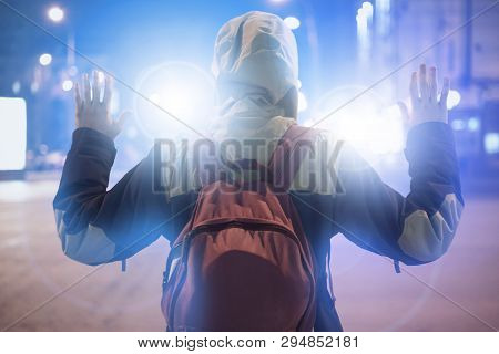 Male Suspect Arrested In The Night City, With Police Flashers Behind Him