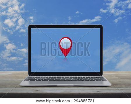 Map Pin Point Location Button With Modern Laptop Computer On Wooden Table Over Blue Sky With White C