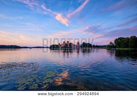 Trakai Island Castle in lake Galve, Lithuania on sunset with dramatic sky reflecting in water. Trakai Castle is one of major tourist attractions of Lituania