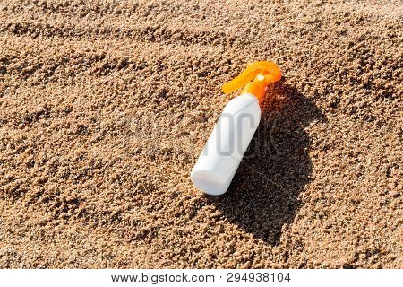 Suntan Lotion White Bottle On Sand With Copy Space. Sunblock Spf Cream On The Sea Beach In Summer Va