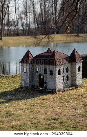 Doghouse In Shape Of A Castle On The River Bank In A Park
