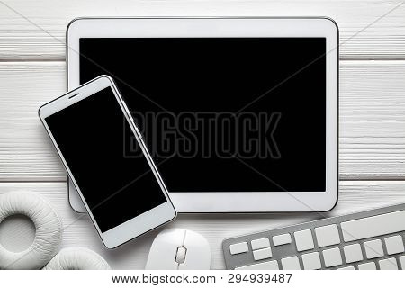 White Modern Smartphone And Digital Tablet, Headphones, Computer Mouse And Keyborad On White Backgro