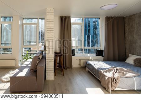 Open Living Room With Couch, Brick Wall And Small Kitchen
