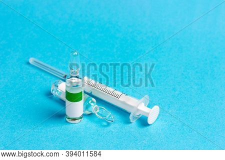 A Syringe And Several Ampoules Of Medicine Or Vitamins.
