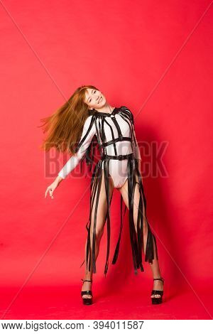 Young Beautiful Dancer Posing In Studio On Red Background