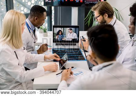 Top Angle View Of Five Multiracial Confident Doctors Discussing Ct Scan Results Of Patient While Hav