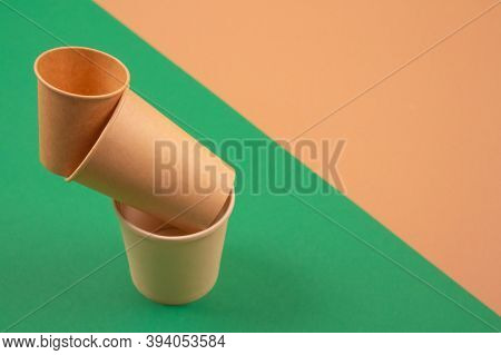 Set Of Balancing Bioderadable Takeaway Beverages Cups - Kraft Paper Coffee Cups On Green And Brown B