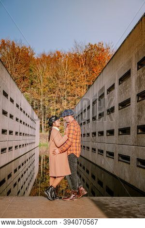 Couple Men And Woman Hiking In The Forest During Autumn And Small Streaming Water River With Fall Co