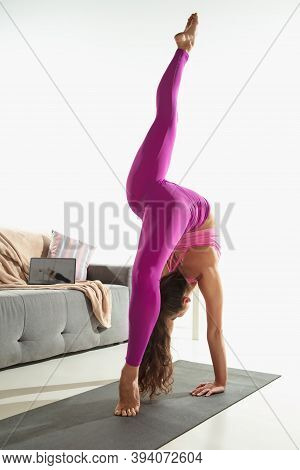 Vitality. Beautiful Young Woman Working Out Indoors, Doing Yoga Exercise On Gray Mat At Home. Long H