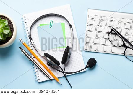 Office desk with headset and supplies. Remote office and work from home concept. Top veiw flat lay with copy space