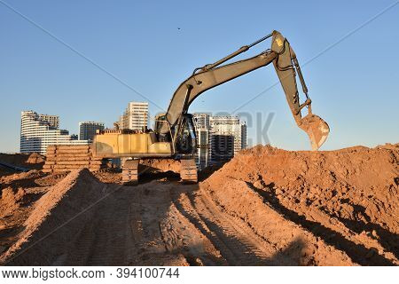 Excavator On Earthworks At Construction Site. Backhoe On Foundation Work And Road Construction. Towe