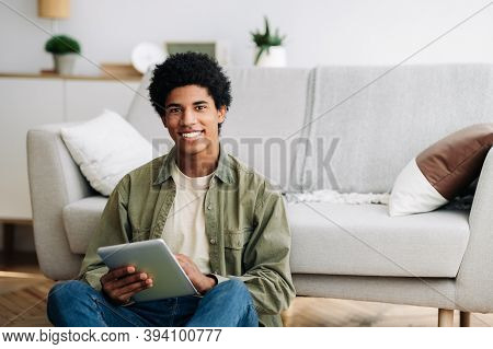 Web Based Learning. Positive Black Male Student With Tablet Computer Looking At Camera And Smiling A