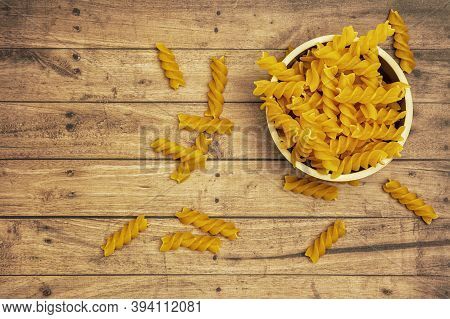 Bowl Of Spirelli With A Wooden Background, Copy Space And Top View