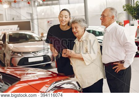 Stylish And Elegant Old Couple In A Car Salon
