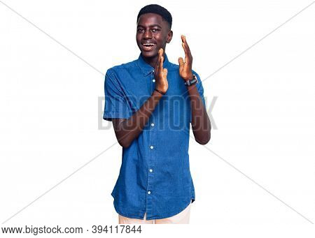 Young african american man wearing casual clothes clapping and applauding happy and joyful, smiling proud hands together 
