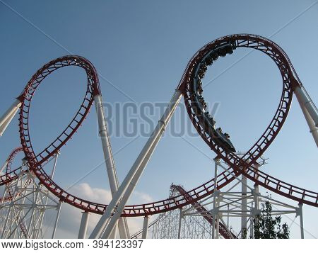 An Exciting Roller Coaster Ride At The Amusement Park. People In Chairs Fly At Dizzying Speeds. Bott