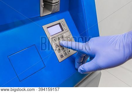 A Man's Hand In Protective Medical Gloves Dials A Pincode At The Terminal For Issuing Money, Close-u