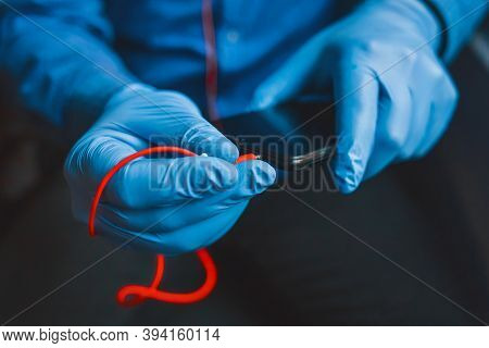 Hands In Protective Medical Gloves Hold A Phone And Connect Red Headphones, Soft Focus