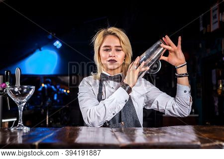 Sweet Girl Bartender Mixes A Cocktail While Standing Near The Bar Counter In Nightclub