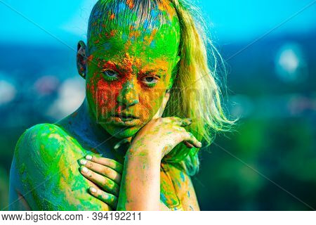 Color Face With Colorful Holi Splash. Cheerful Young Woman With Colorful Paint On Bodies Having Fun 