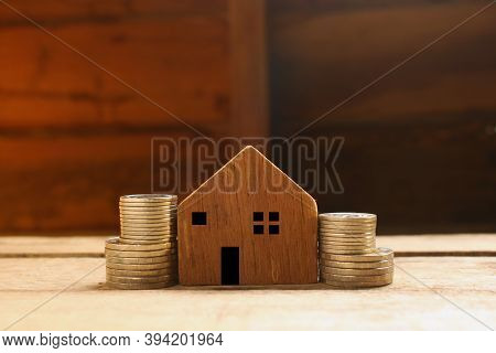 Real Estate Investment,image Of Stack Of Cions With Wooden House Model,concept For Buy,sell,or Rent