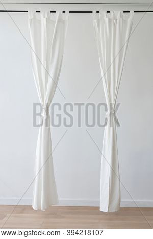 White drapery hanging from a curtain rod