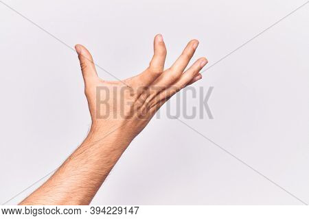 Close up of hand of young caucasian man over isolated background picking and taking invisible thing, holding object with fingers showing space 