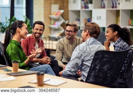 Creating Success. Group Of Young Happy Multi Racial Business People Communicating And Sharing Ideas 