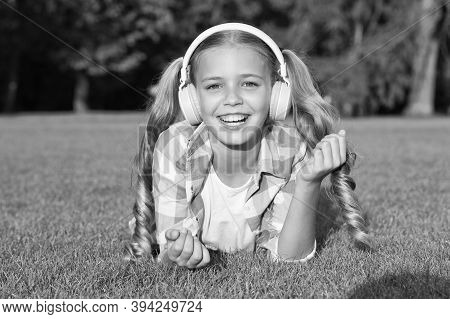 Just Nice Day. Relax On Green Grass In Headphones. Small Girl Listen Audio Book. New Technology For 