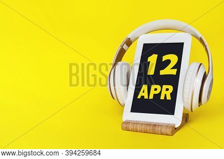 April 12nd. Day 12 Of Month, Calendar Date. Stylish Headphones And Modern Tablet On Yellow Backgroun