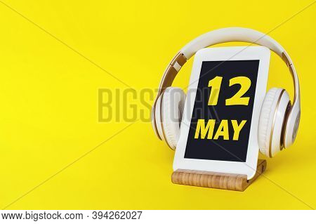 May 12nd. Day 12 Of Month, Calendar Date. Stylish Headphones And Modern Tablet On Yellow Background.