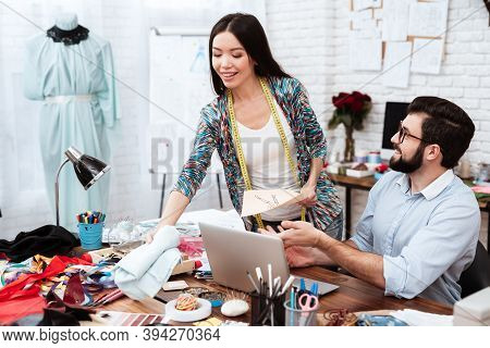 Two Fashion Designers Discussing Model Drawing.