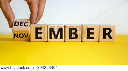 Symbol For The Change From November To December. Male Hand Flips Wooden Cubes And Changes The Inscri