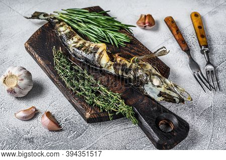 Cooked Mackerel Icefish On A Wooden Cutting Board. Black Background. Top View