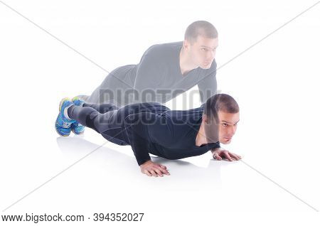 Concentrated Young Sportsman Exercising And Doing Push Ups On The White Background. Studio Shoot