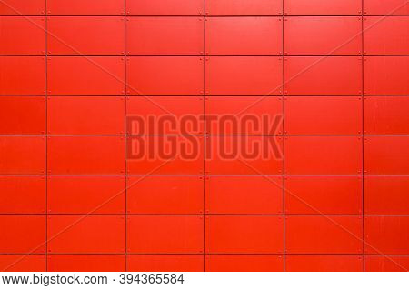 Texture Of The Iron Facade Of An Industrial Building Made Of Sheet Metal Panels With Rivets, A Close