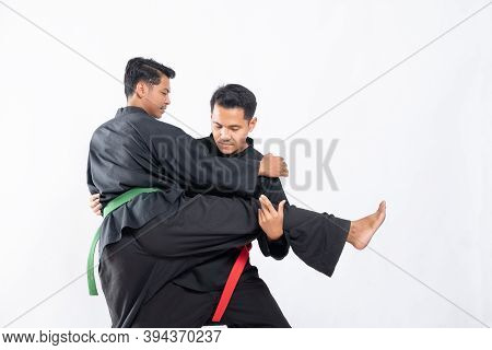 Two Fighters In Black Pencak Silat Uniform Fight In Locks And Slams
