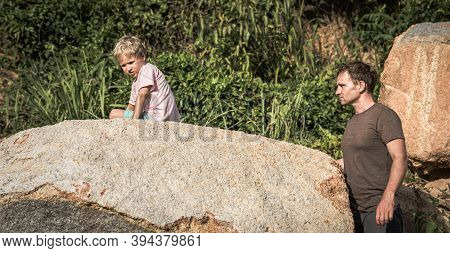 Sad Serious Boy Bored Climbed Hiding On Stone. Loving Father Wants To Help. Family Relations Closene