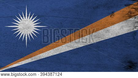 Flag Of Marshall Islands On Wooden Plate Background. Grunge Marshall Flag Texture, A Blue Field With