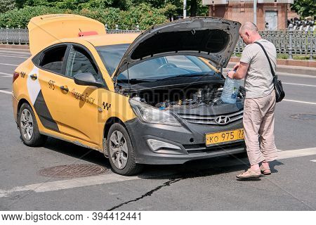Moscow \ Russia 06 10 2019: Driver Yandex Taxi Saves The Car From Overheating On A Hot Day. Taxi Dri