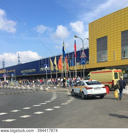 People In Medical Masks Stand In Line To Enter Near The Ikea Store. Sunny Day After Lifting The Quar